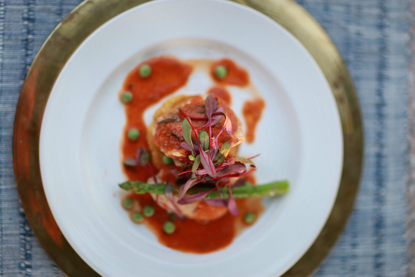 Rendez-vous Winery gourmet dish with seafood, sauce, and microgreens on a white plate with a gold rim.